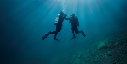 En dykker støtter en annen dykker som opplever problemer med lufttilførselen.